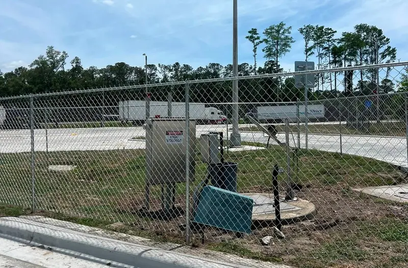 Galvanized chain link fence around a utility enclosure at a new commercial lot, built by Southern Line Fence & Finish